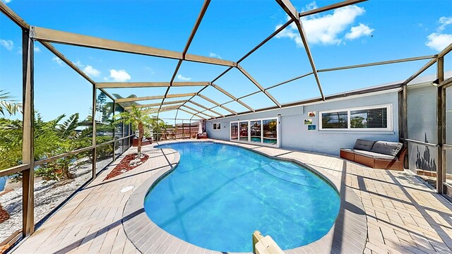 outdoor pool featuring a patio area and glass enclosure
