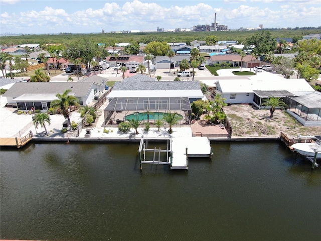 aerial perspective of suburban area featuring a nearby body of water and a pool