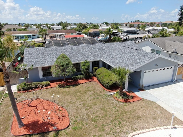 ranch-style house featuring a garage, roof with shingles, a residential view, and concrete driveway