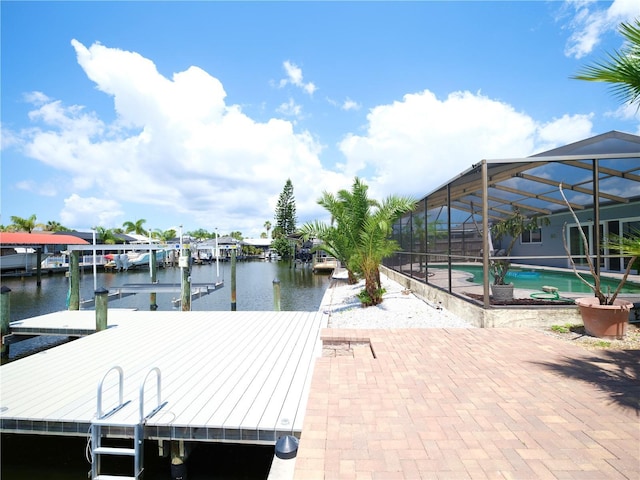 dock area with an outdoor pool, a water view, a lanai, boat lift, and a patio
