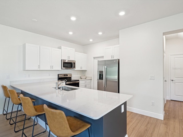 17729 Nectar Flume Dr, Land O Lakes, FL 34638 - kitchen with appliances with stainless steel finishes, a kitchen bar, light wood-style flooring, a peninsula, and recessed lighting