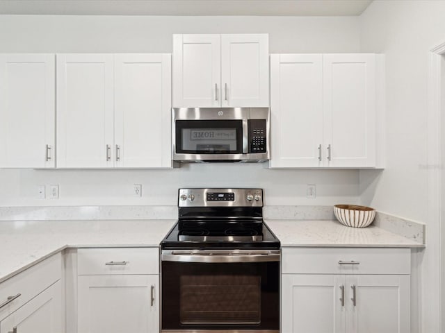 17729 Nectar Flume Dr, Land O Lakes, FL 34638 - kitchen featuring stainless steel appliances, white cabinetry, and light stone countertops