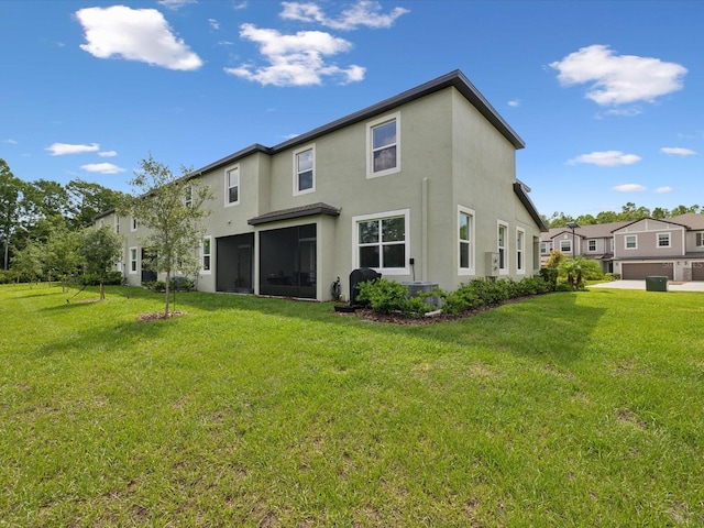 17729 Nectar Flume Dr, Land O Lakes, FL 34638 - rear view of house featuring stucco siding, a lawn, and a sunroom