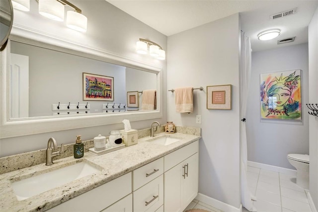 100 Bluff View Dr Unit 405A, Belleair Bluffs, FL 33770 - full bath featuring tile patterned floors, baseboards, double vanity, and toilet