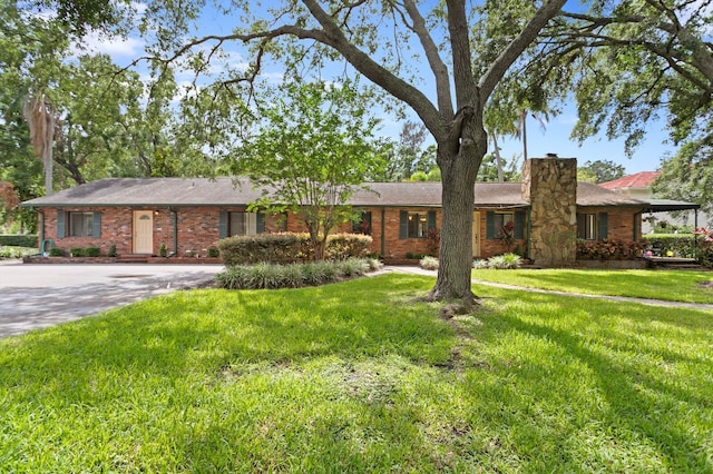 3005 W Sligh Ave, Tampa, FL 33614 - ranch-style home featuring a chimney, brick siding, driveway, and a front yard