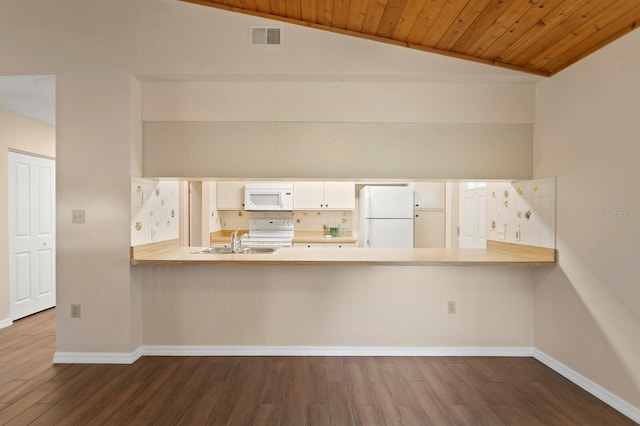 3005 W Sligh Ave, Tampa, FL 33614 - kitchen with white appliances, a peninsula, dark wood-style flooring, lofted ceiling, and decorative backsplash