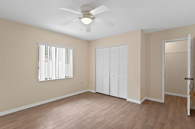 3005 W Sligh Ave, Tampa, FL 33614 - unfurnished bedroom with wood finished floors, a closet, baseboards, a ceiling fan, and a textured ceiling