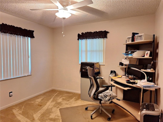 office space with carpet flooring, a textured ceiling, ceiling fan, and baseboards