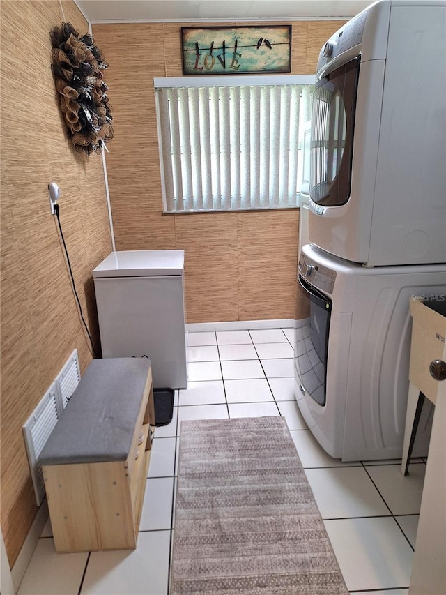 washroom featuring stacked washer / dryer and light tile patterned floors