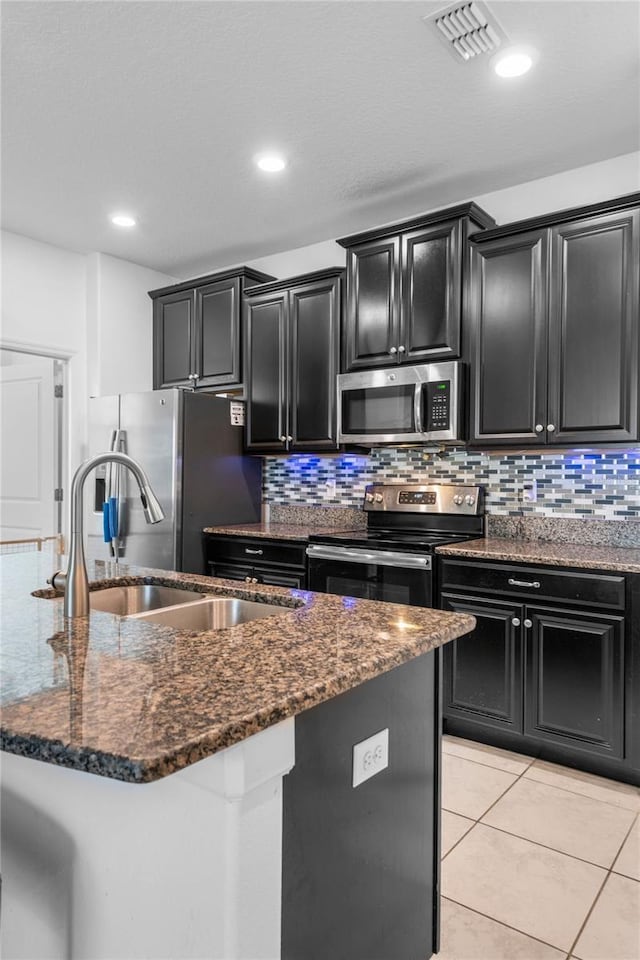 9931 Victory Gallop Loop, Ruskin, FL 33573 - kitchen featuring stainless steel appliances, dark cabinetry, a sink, and recessed lighting