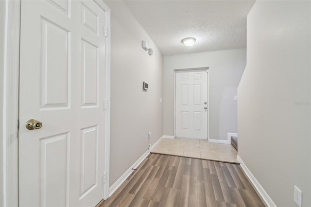 4528 Winding River Way, Land O Lakes, FL 34639 - doorway to outside with a textured ceiling, light wood-style flooring, and baseboards