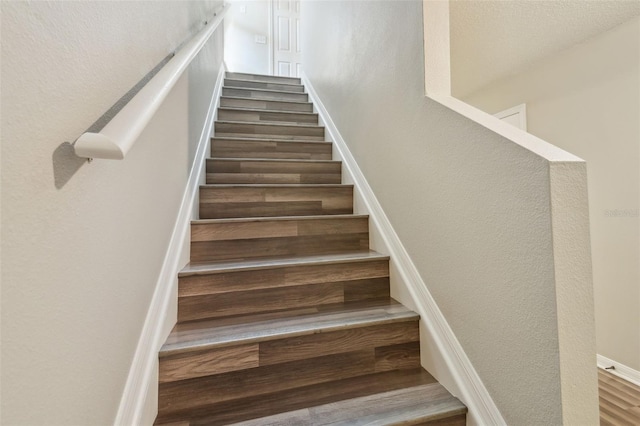 4528 Winding River Way, Land O Lakes, FL 34639 - stairway featuring wood finished floors, baseboards, and a textured wall