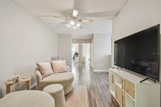 4528 Winding River Way, Land O Lakes, FL 34639 - living area featuring ceiling fan, light wood-type flooring, baseboards, and a textured ceiling