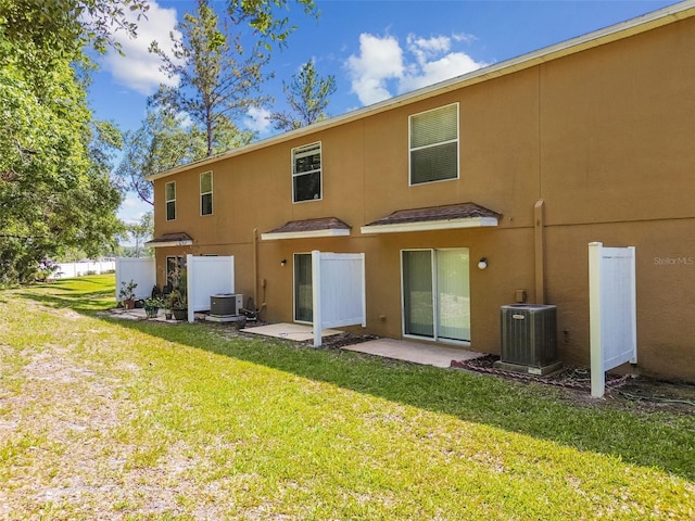 4528 Winding River Way, Land O Lakes, FL 34639 - back of house with central AC unit, a lawn, and stucco siding