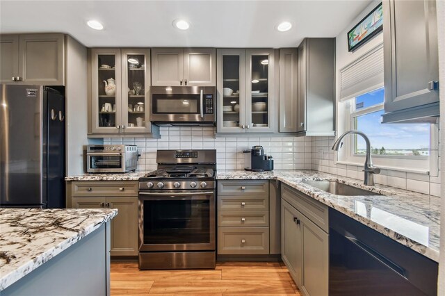 2960 59th St S Unit 614, Gulfport, FL 33707 - kitchen featuring appliances with stainless steel finishes, a sink, gray cabinets, light stone counters, and recessed lighting