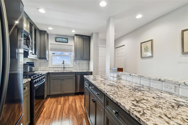 2960 59th St S Unit 614, Gulfport, FL 33707 - kitchen with appliances with stainless steel finishes, a sink, light wood finished floors, light stone countertops, and recessed lighting