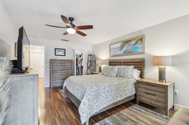 2960 59th St S Unit 614, Gulfport, FL 33707 - bedroom featuring a walk in closet, wood finished floors, a closet, a ceiling fan, and baseboards