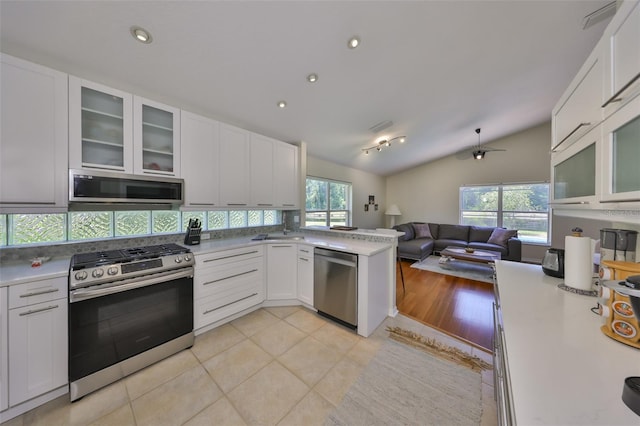 14502 Pond Cypress Way, Tampa, FL 33626 - kitchen with appliances with stainless steel finishes, open floor plan, vaulted ceiling, white cabinetry, and glass insert cabinets
