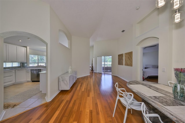 14502 Pond Cypress Way, Tampa, FL 33626 - corridor featuring a high ceiling, healthy amount of natural light, arched walkways, and light wood finished floors