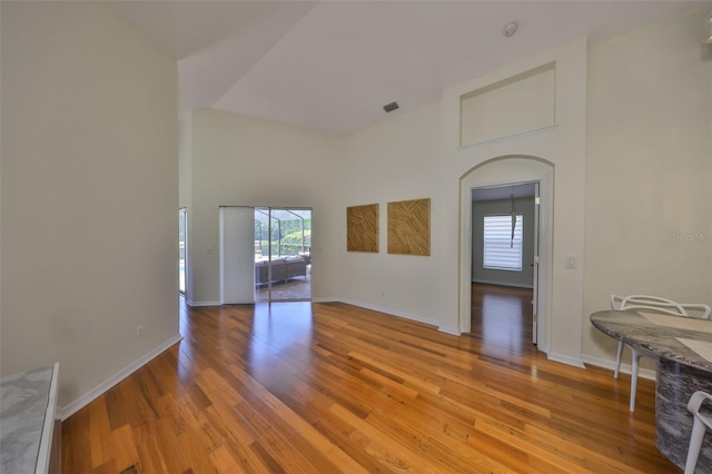 14502 Pond Cypress Way, Tampa, FL 33626 - spare room featuring healthy amount of natural light, wood finished floors, a towering ceiling, baseboards, and arched walkways