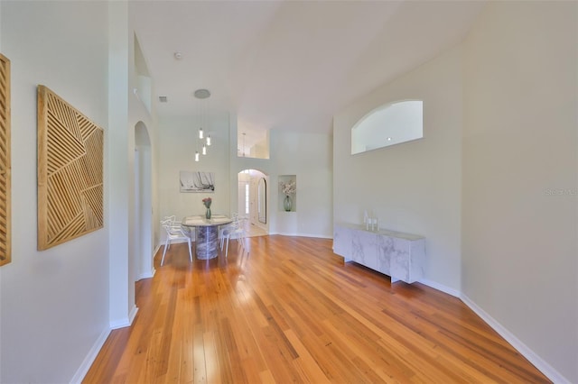 14502 Pond Cypress Way, Tampa, FL 33626 - hallway with arched walkways, light wood-type flooring, a high ceiling, and baseboards
