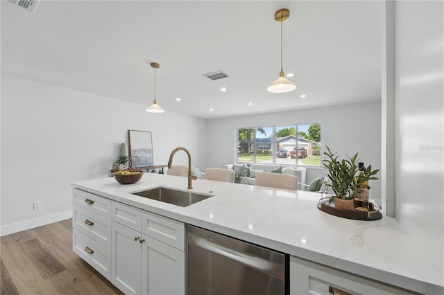 2815 Golfview Dr, Melbourne, FL 32901 - kitchen with stainless steel dishwasher, a sink, white cabinetry, hanging light fixtures, and recessed lighting
