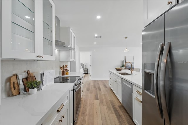 2815 Golfview Dr, Melbourne, FL 32901 - kitchen featuring appliances with stainless steel finishes, a sink, light wood-style flooring, white cabinetry, and light stone countertops