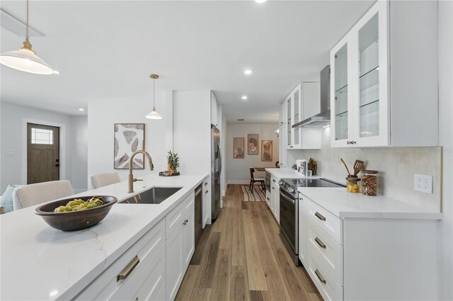 2815 Golfview Dr, Melbourne, FL 32901 - kitchen featuring stainless steel appliances, a sink, wall chimney range hood, white cabinetry, and recessed lighting