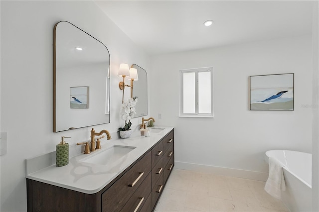 2815 Golfview Dr, Melbourne, FL 32901 - full bathroom featuring baseboards, double vanity, a freestanding bath, and recessed lighting