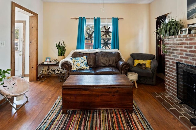 living area with wood finished floors, healthy amount of natural light, and a fireplace