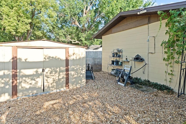 view of yard featuring a storage unit, an outbuilding, and fence