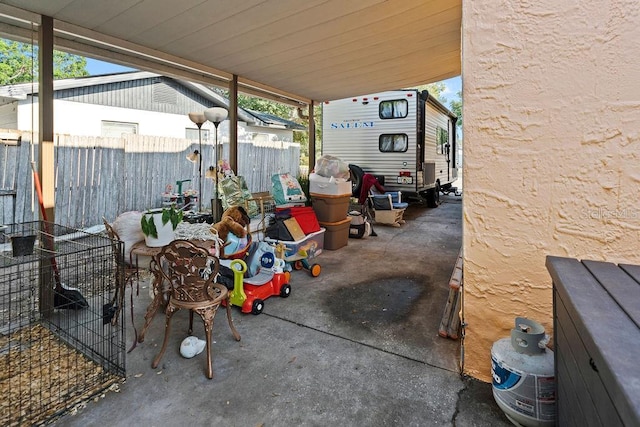 view of patio / terrace with fence and a carport
