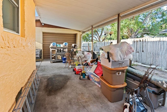 view of patio featuring fence and a garage