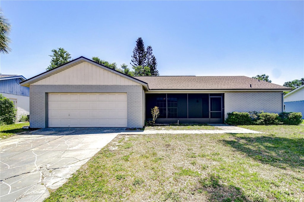 12846 Tallowood Dr, Riverview, FL 33569 - single story home with brick siding, a sunroom, an attached garage, driveway, and a front lawn