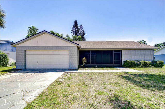 12846 Tallowood Dr, Riverview, FL 33569 - single story home with brick siding, a sunroom, an attached garage, driveway, and a front lawn