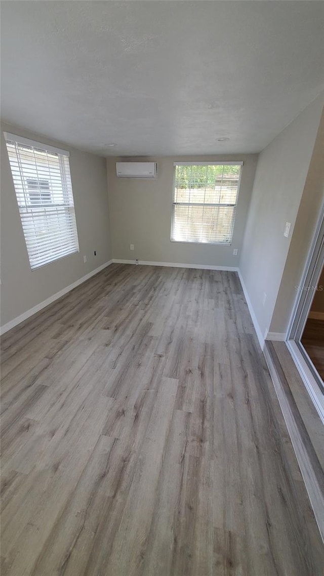 312 Dorothy Ave, Daytona Beach, FL 32117 - unfurnished room featuring wood finished floors, an AC wall unit, and baseboards