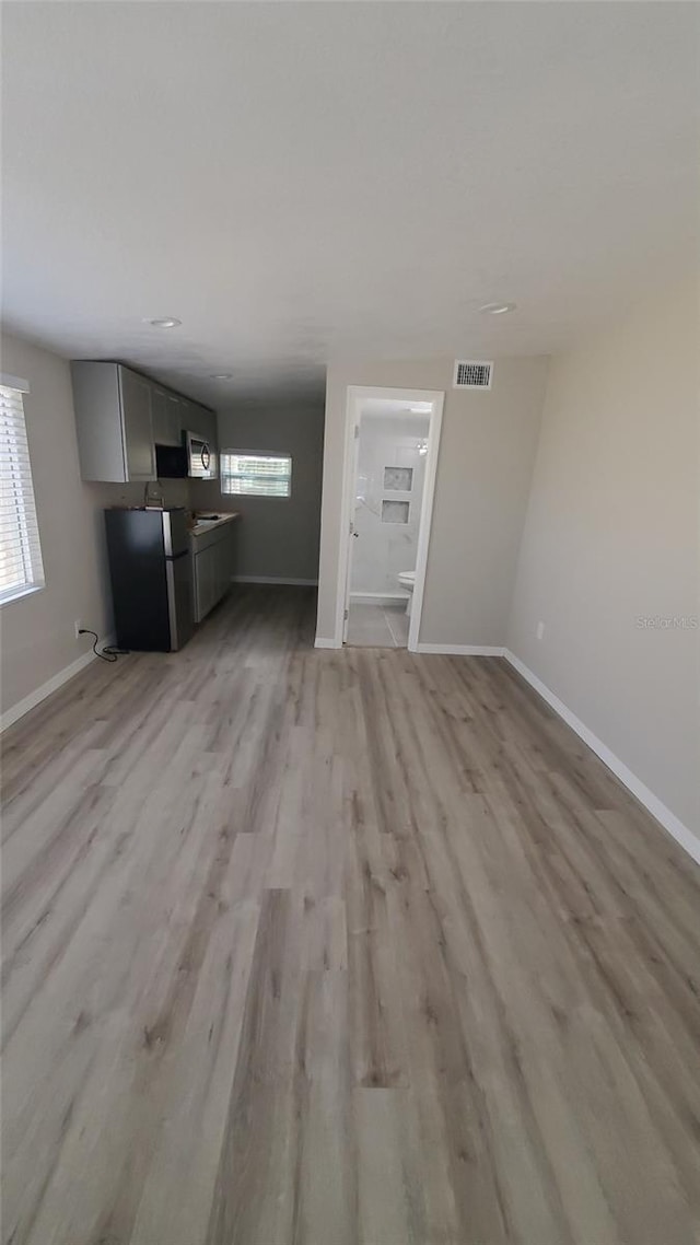 312 Dorothy Ave, Daytona Beach, FL 32117 - unfurnished living room with baseboards and light wood finished floors