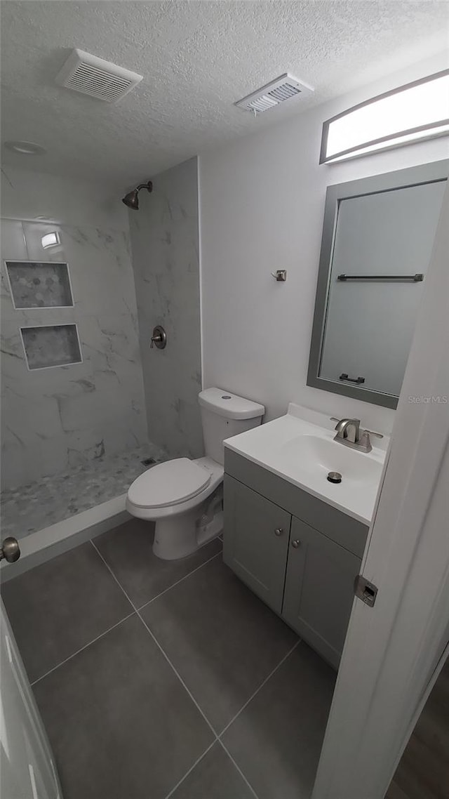 312 Dorothy Ave, Daytona Beach, FL 32117 - full bath with a textured ceiling, a stall shower, vanity, toilet, and tile patterned floors
