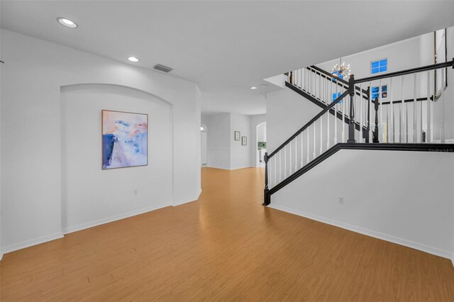 3002 Savannah Oaks Cir, Tarpon Springs, FL 34688 - unfurnished living room with wood finished floors, stairway, baseboards, recessed lighting, and a chandelier