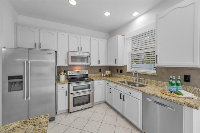 3002 Savannah Oaks Cir, Tarpon Springs, FL 34688 - kitchen with appliances with stainless steel finishes, a sink, white cabinetry, light stone counters, and recessed lighting