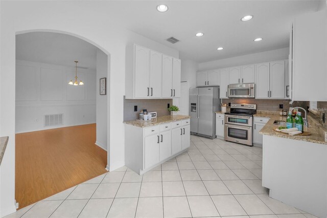 3002 Savannah Oaks Cir, Tarpon Springs, FL 34688 - kitchen featuring appliances with stainless steel finishes, a sink, light stone countertops, backsplash, and recessed lighting