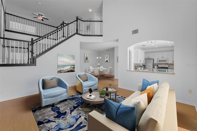 3002 Savannah Oaks Cir, Tarpon Springs, FL 34688 - living room with a ceiling fan, a high ceiling, wood finished floors, baseboards, and arched walkways