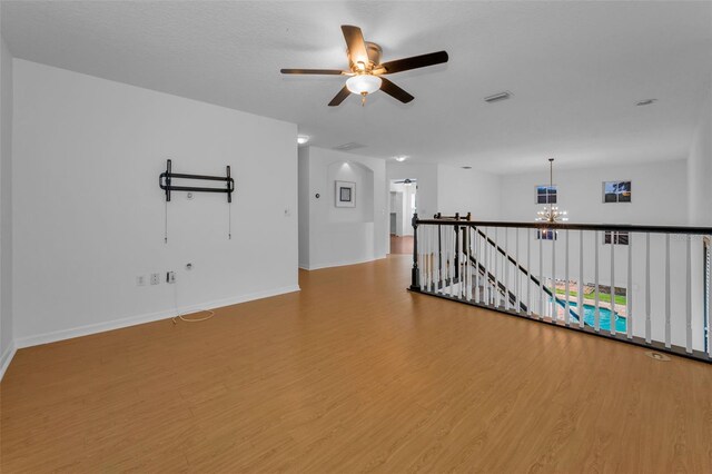 3002 Savannah Oaks Cir, Tarpon Springs, FL 34688 - spare room with a chandelier, wood finished floors, a ceiling fan, and baseboards