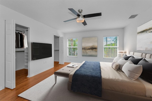 3002 Savannah Oaks Cir, Tarpon Springs, FL 34688 - bedroom featuring multiple windows, wood finished floors, baseboards, and a ceiling fan
