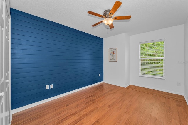 3002 Savannah Oaks Cir, Tarpon Springs, FL 34688 - unfurnished room with baseboards, wood finished floors, a ceiling fan, and a textured ceiling