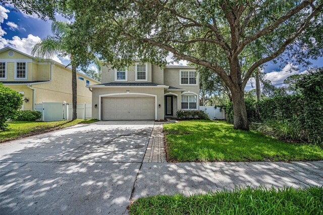 3002 Savannah Oaks Cir, Tarpon Springs, FL 34688 - traditional-style home featuring stucco siding, driveway, an attached garage, and a gate