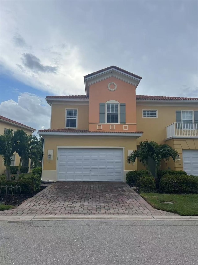 16217 Via Solera Cir Unit 101, Fort Myers, FL 33908 - view of front of property with a garage, stucco siding, and decorative driveway