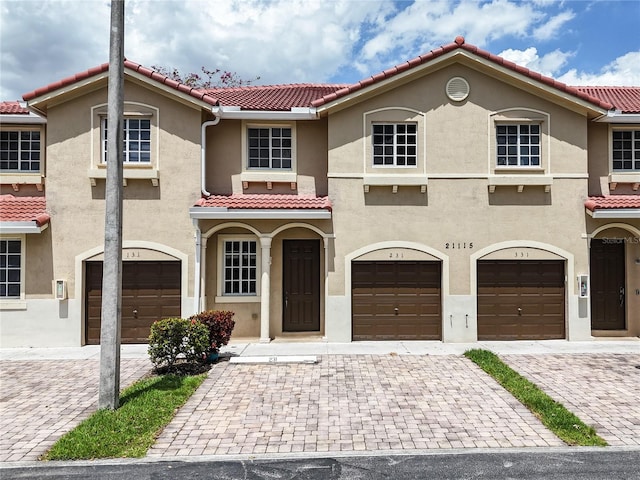21115 NW 14th Pl Unit 2, Miami, FL 33169 - view of front facade with a tile roof, stucco siding, a garage, and driveway