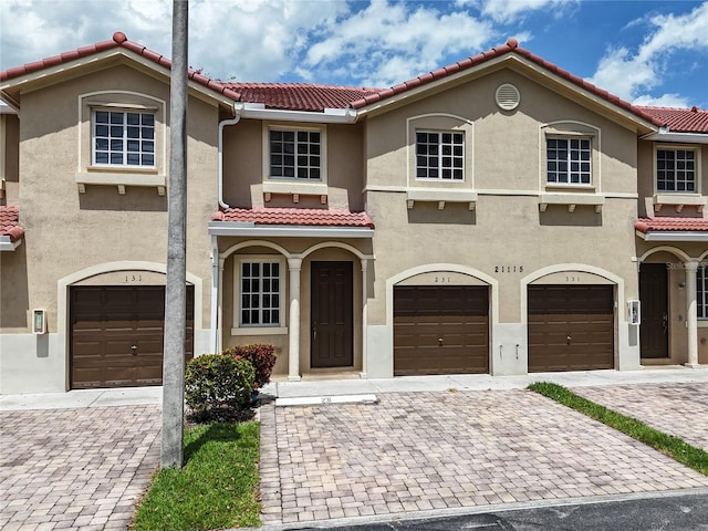 21115 NW 14th Pl Unit 2, Miami, FL 33169 - view of front of property with stucco siding, a tile roof, a garage, and driveway