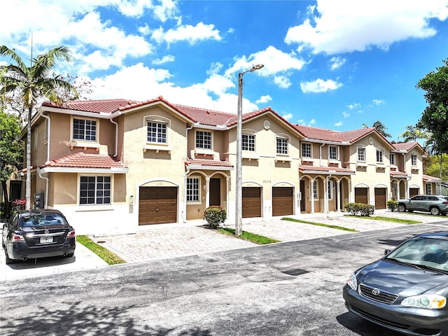 21115 NW 14th Pl Unit 2, Miami, FL 33169 - view of front facade featuring stucco siding, a garage, driveway, and a tiled roof